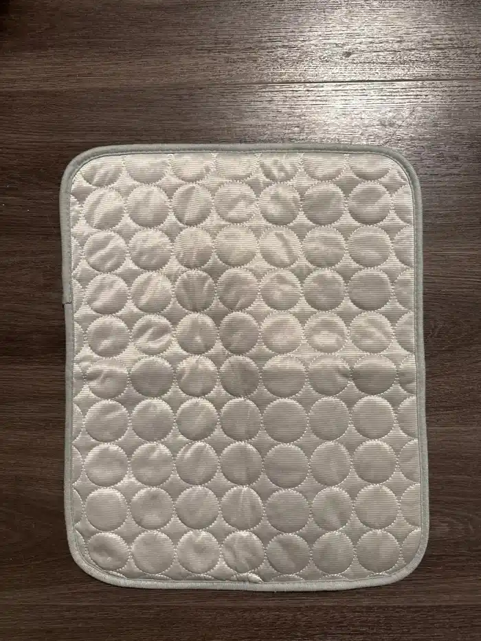 Tapis rafraîchissant gris taille S posé sur un parquet foncé, photo envoyée par un acheteur